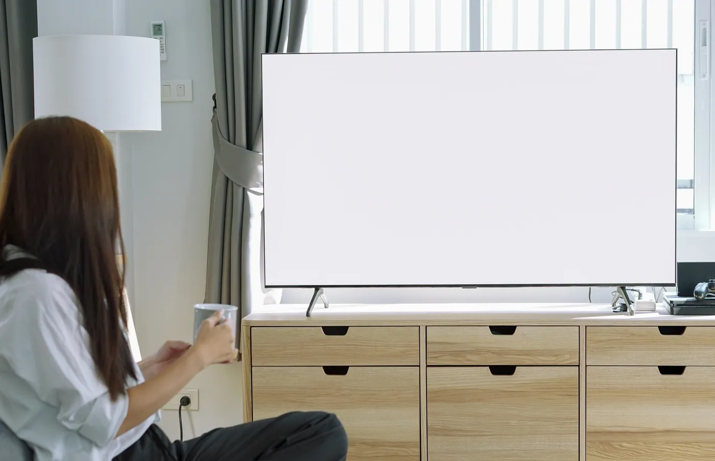 Someone on the sofa with a mug, looking at the family's day on the big living-room TV.